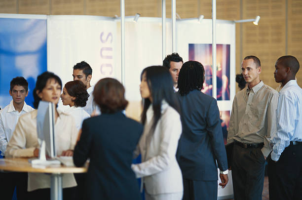 Stand entreprise avec visiteurs pendant un événement professionnel