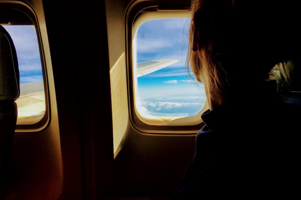 Femme qui regarde par le hublot d'un avion